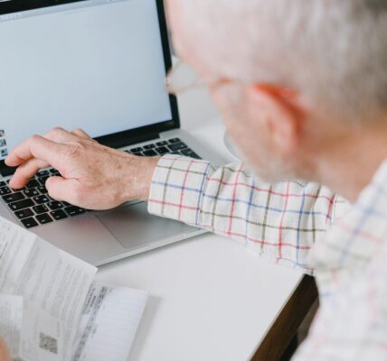 Senior przeglądający dokumenty i szukający starego konta bankowego