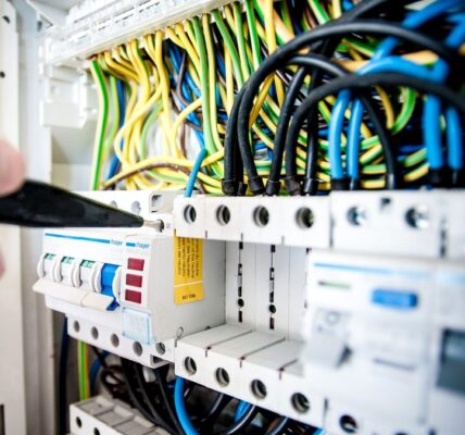 Elektryk pracujący przy rozdzielnicy i zabezpieczeniach elektrycznych
