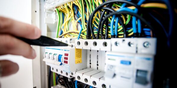 Elektryk pracujący przy rozdzielnicy i zabezpieczeniach elektrycznych