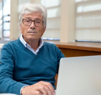 Senior kontynuujący pracę przy komputerze po osiągnięciu wieku emerytalnego