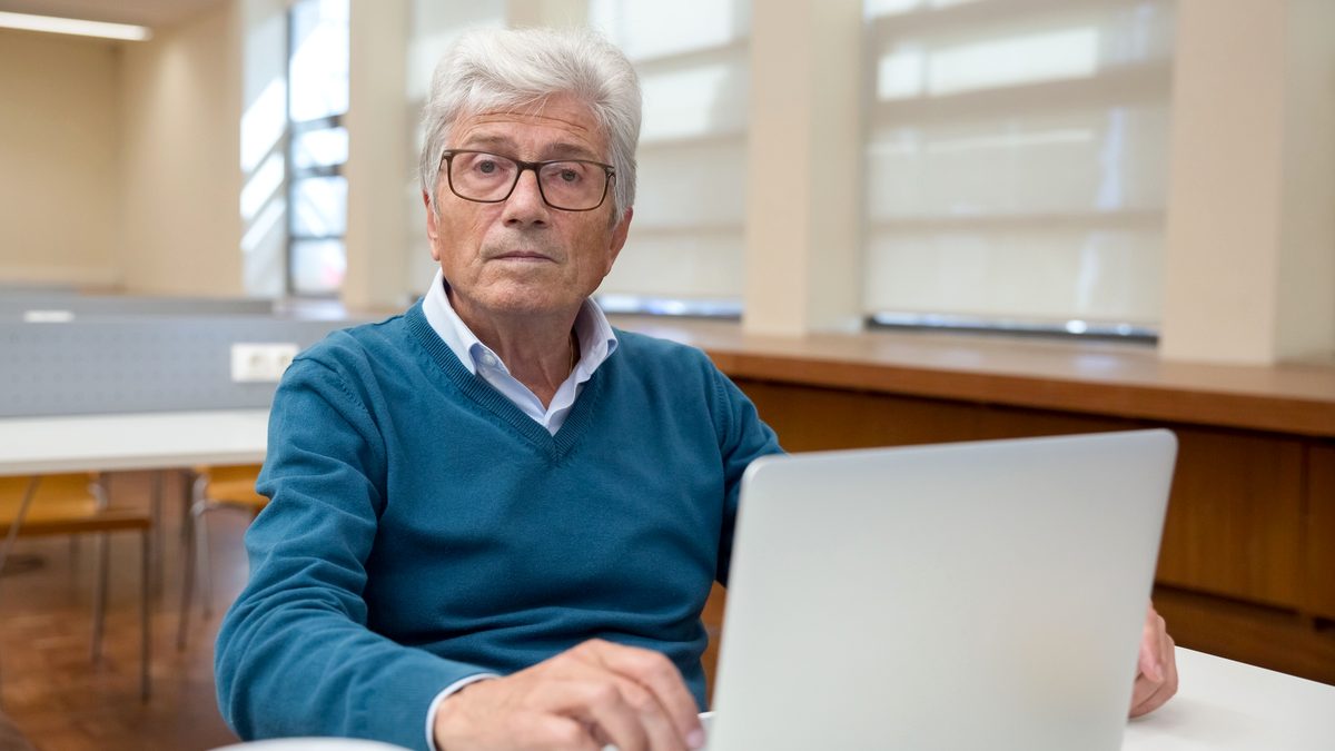 Senior kontynuujący pracę przy komputerze po osiągnięciu wieku emerytalnego